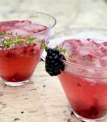 2 blackberry champagne cocktails on marble board