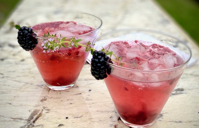 2 blackberry champagne cocktails on marble board