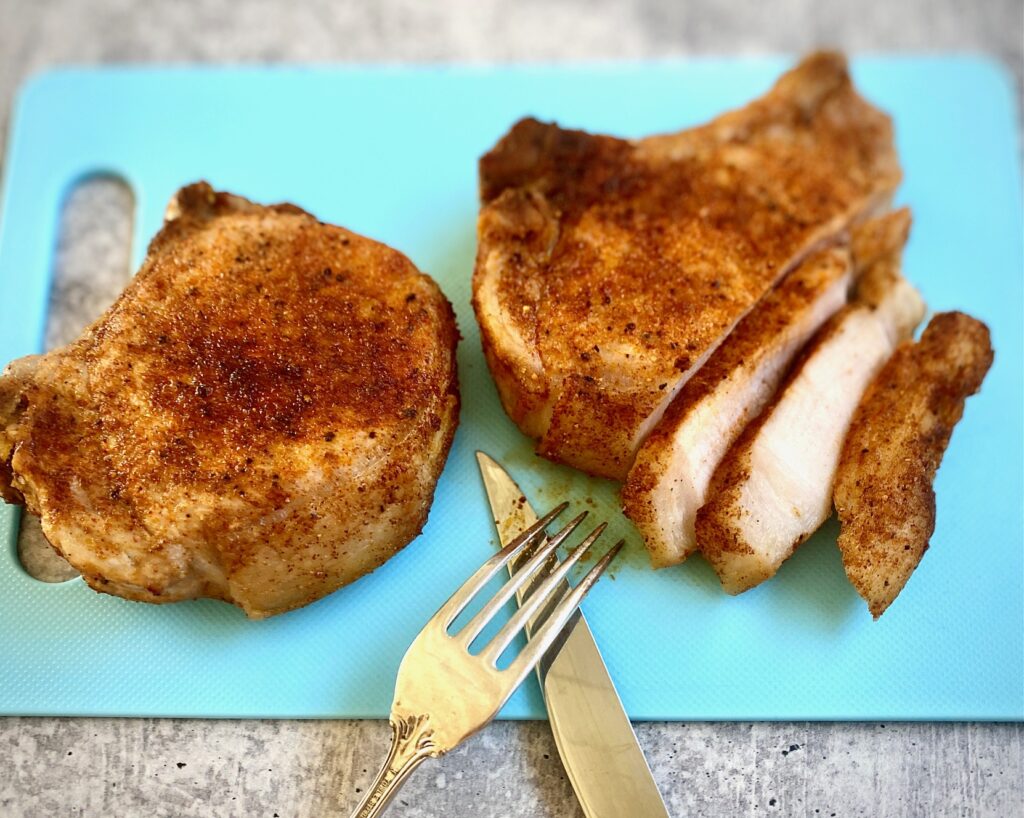 2 pork chops on cutting board