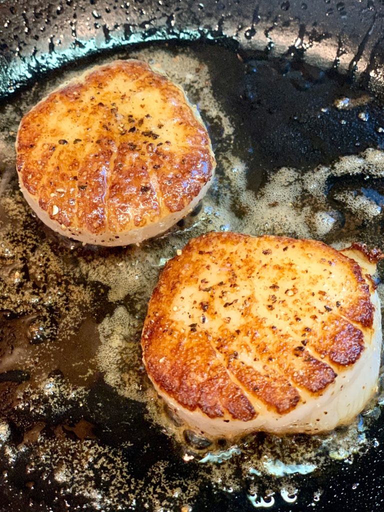2 Scallops searing in cast iron