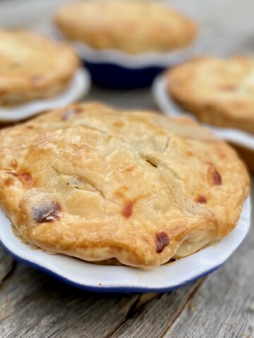 4 pot pies close up on a wood board