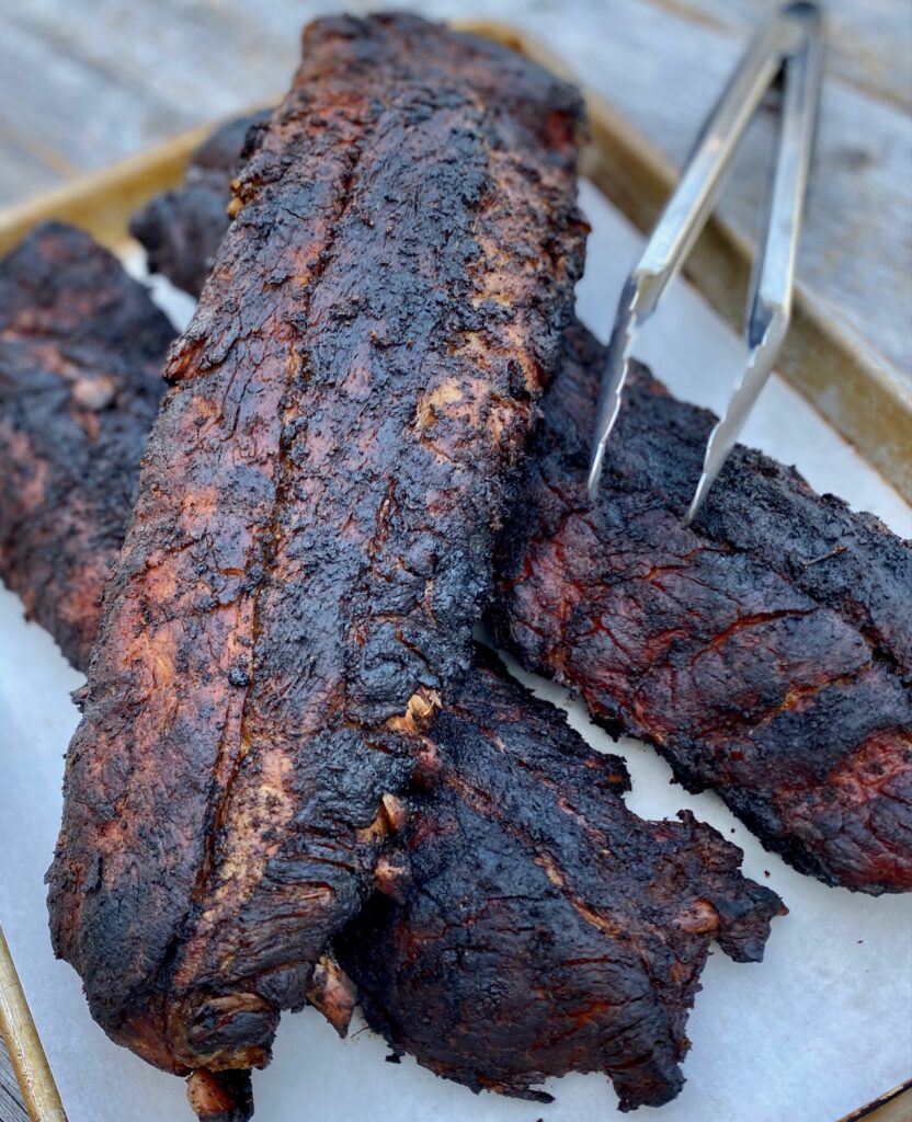 3 racks of pork ribs with tongs