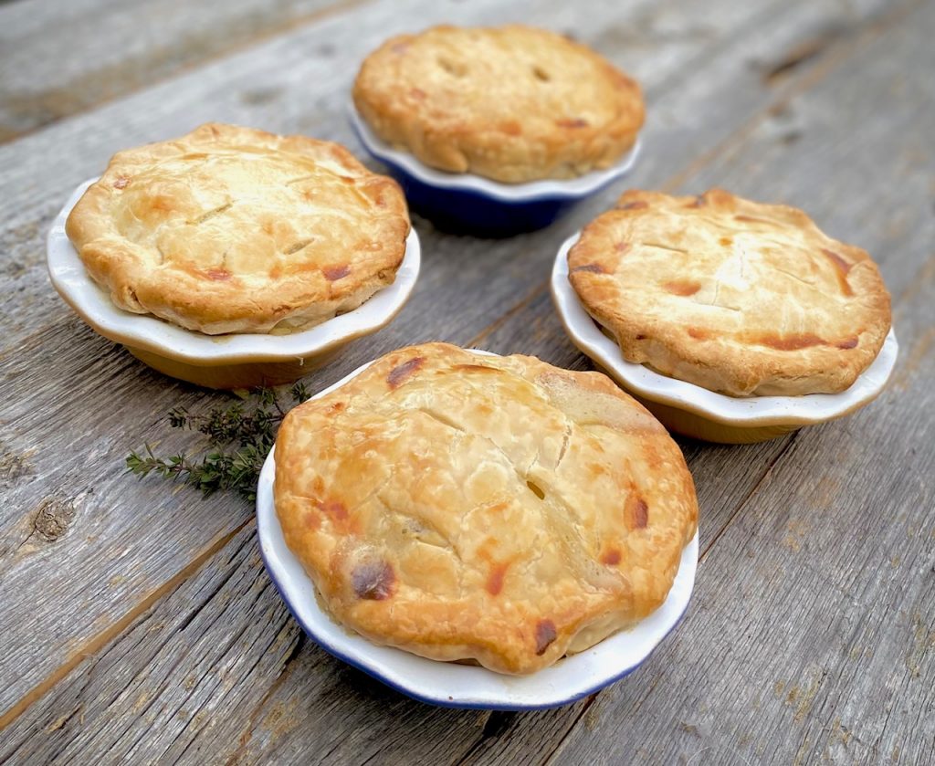 4 individual pot pies on wood board