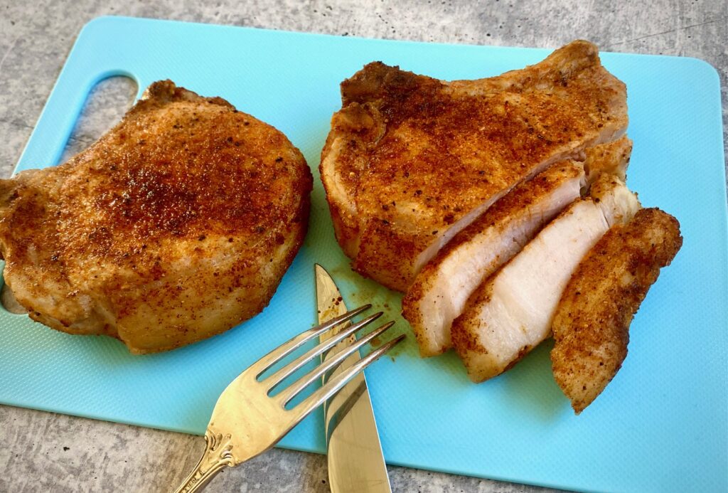 a cutting board with 2 pieces of meat