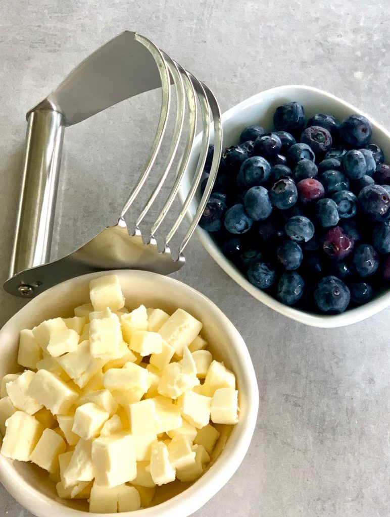 Pastry cutter, chunks of butter, and blueberries