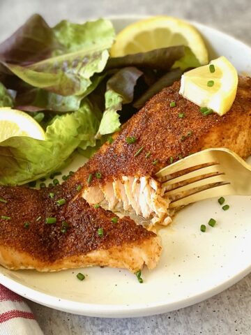 a piece of seasoned salmon + lettuce on a plate