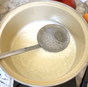 Slotted spoon floats on cheese