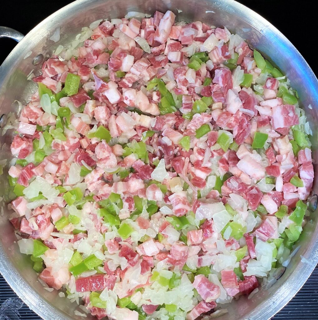 sauteed onion, green pepper and pancetta in a pan