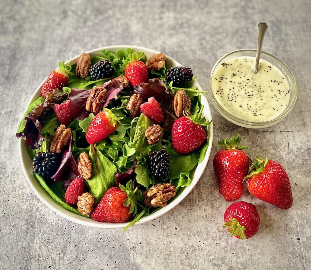 one salad with dressing bowl and 3 strawberries