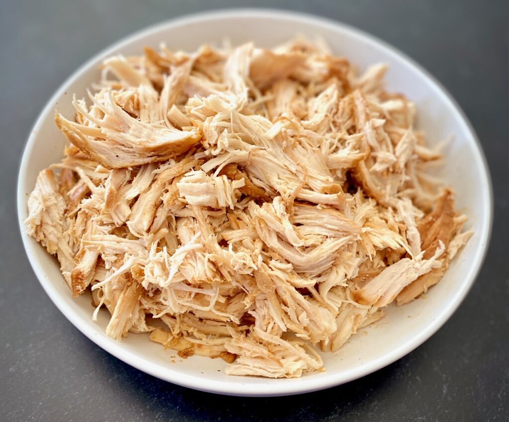 white bowl of shredded chicken