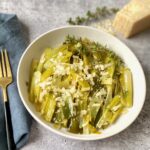 Braised leeks with parmesan cheese in white bowl