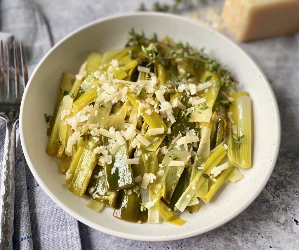 a white bowl of cooked leeks