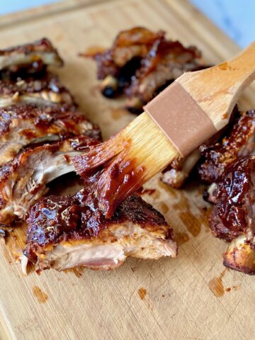 brushing sauce on cut ribs