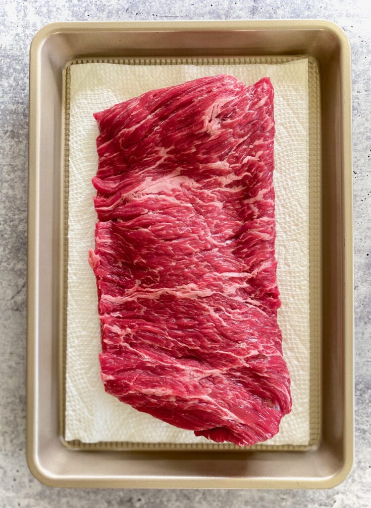 uncooked skirt steak on a tray