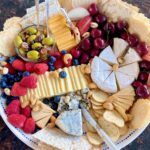 tray with a variety of cheese, crackers, nuts and fruit