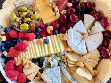 tray with a variety of cheese, crackers, nuts and fruit