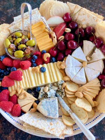 tray with a variety of cheese, crackers, nuts and fruit