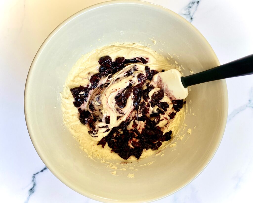 batter with cherries in a mixing bowl