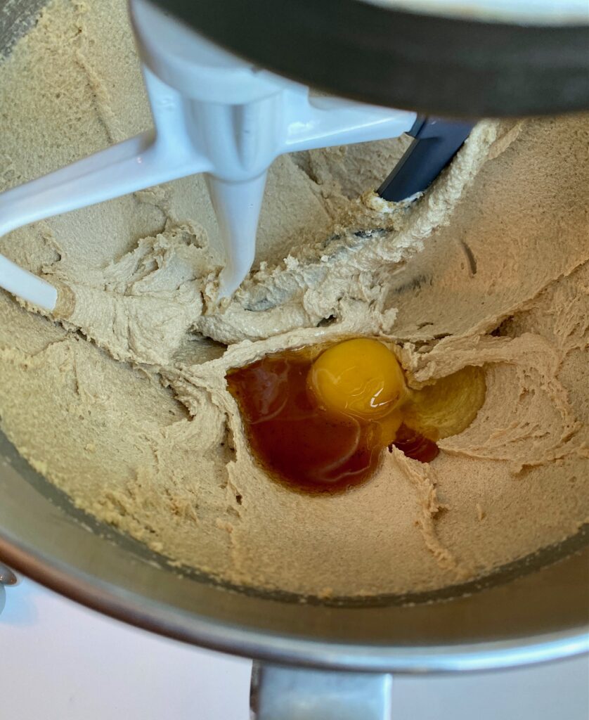 cookie batter with an egg and vanilla in a bowl