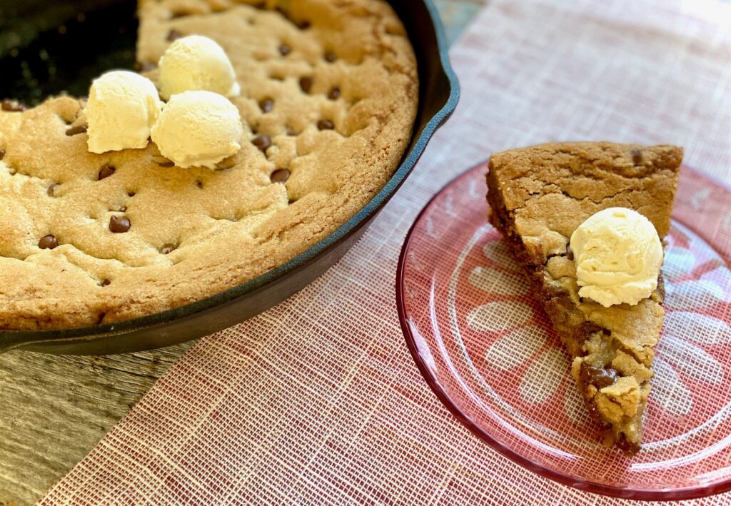 skillet cookie with piece on plate and ice cream on top
