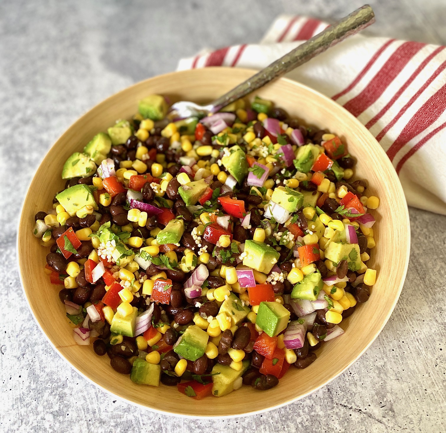 striped red napkin and bowl of black bean and avocado