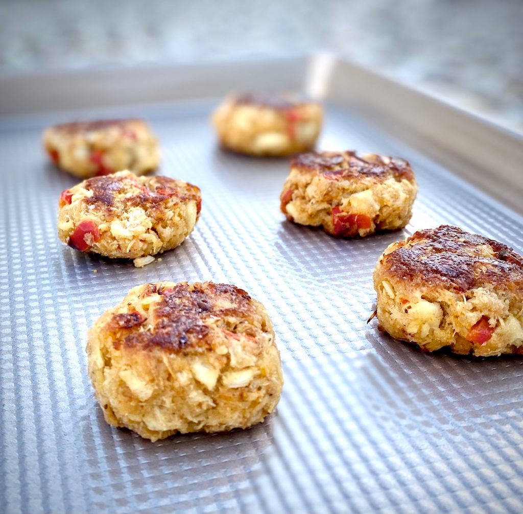 6 crab cakes on a baking sheet