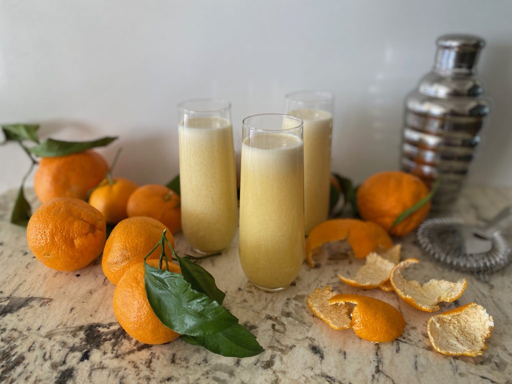 3 glasses and ingredients for orange creamsicle drinks