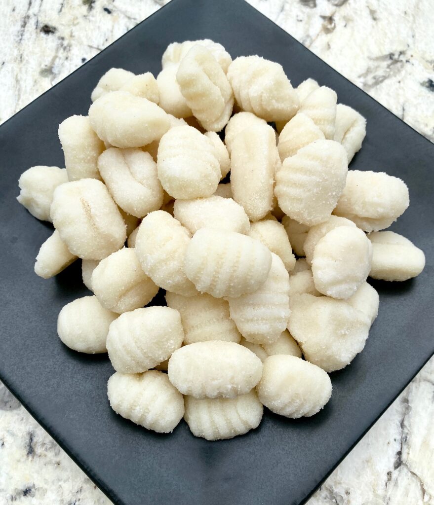 Uncooked Gnocchi on a black plate