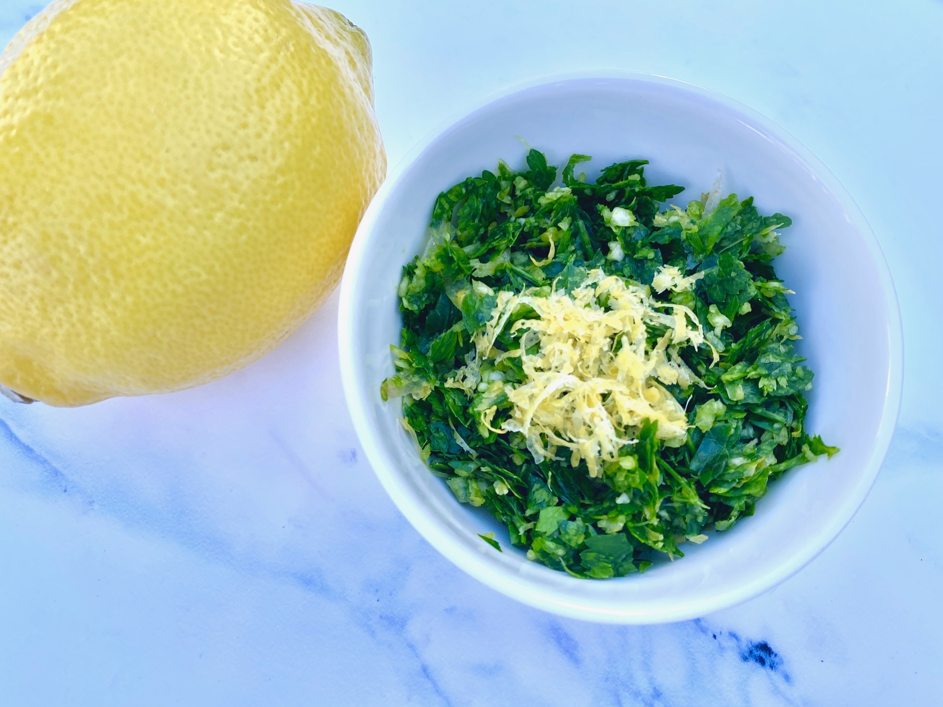 a lemon and a bowl of gremolata