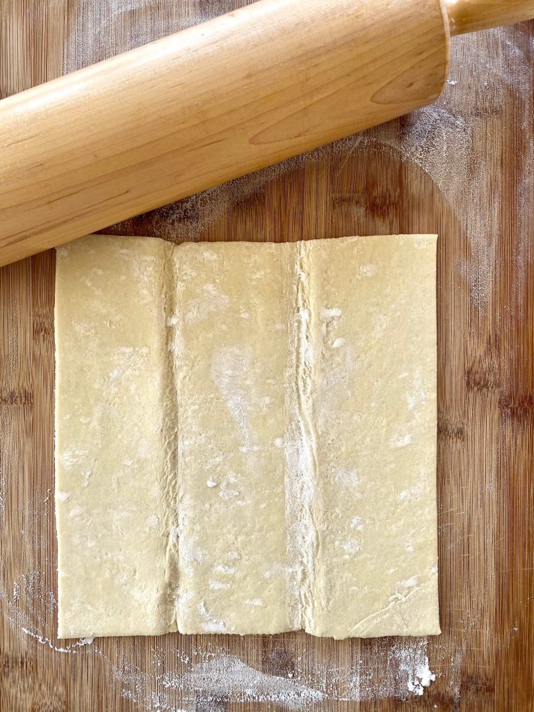 One piece of puff pastry with rolling pin