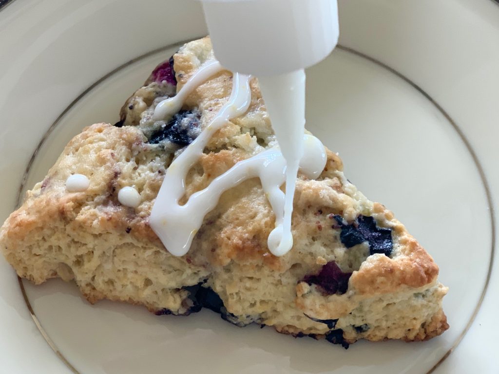 Lemon zest icing drizzled on scones