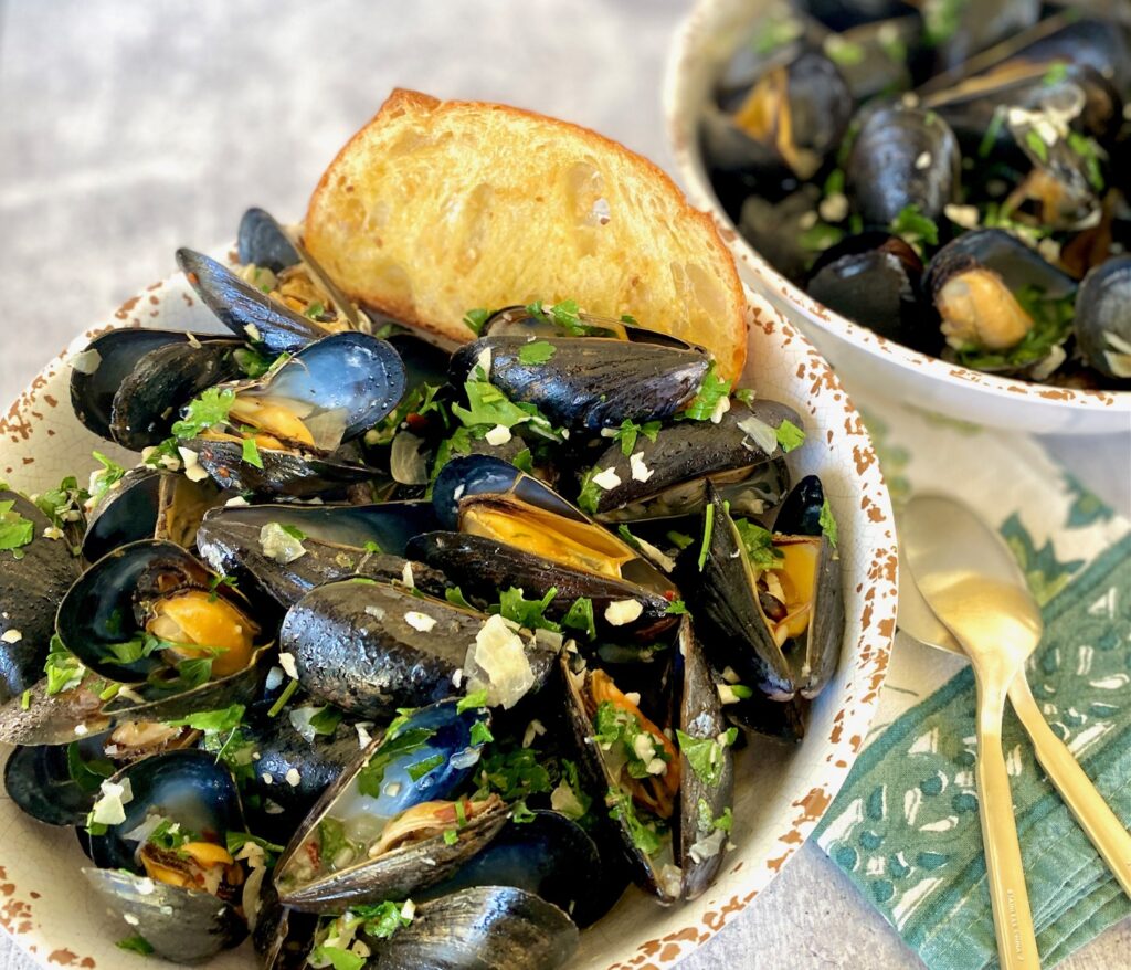 2 bowls of cooked mussels with garlic bread