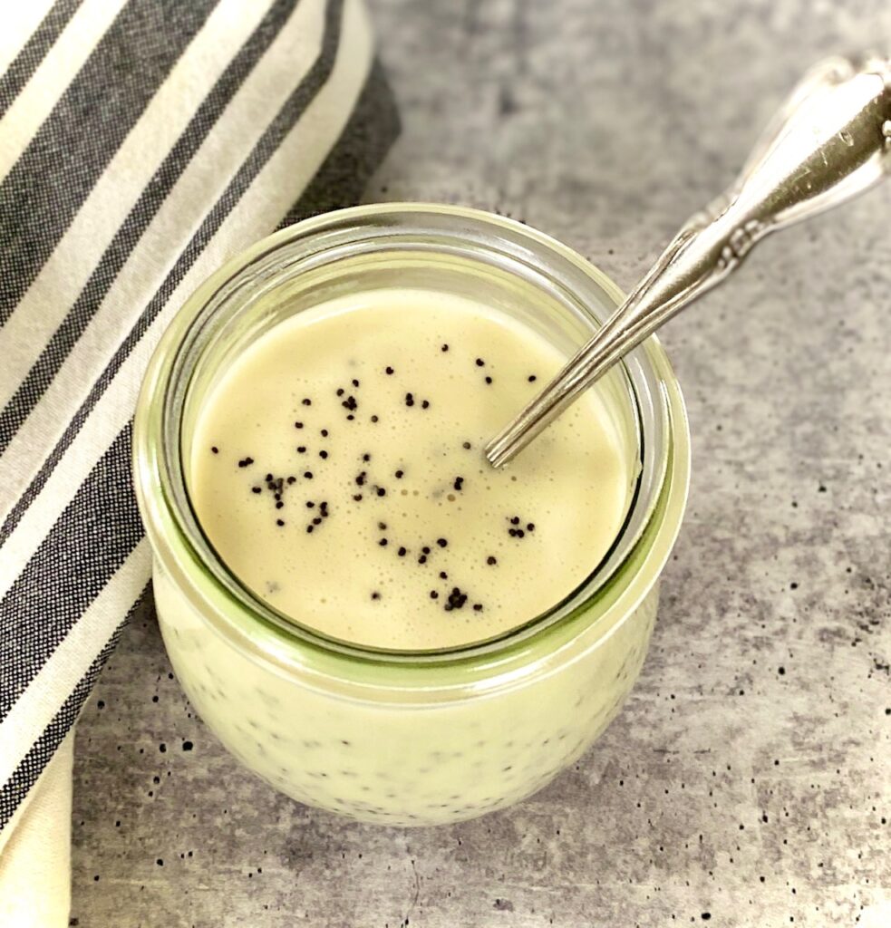 spoon and jar of salad dressing with seeds