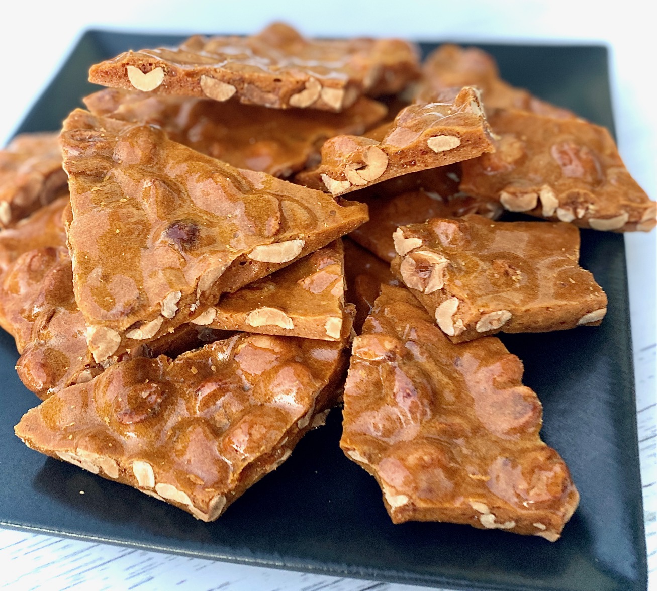 Peanut brittle pieces on black plate