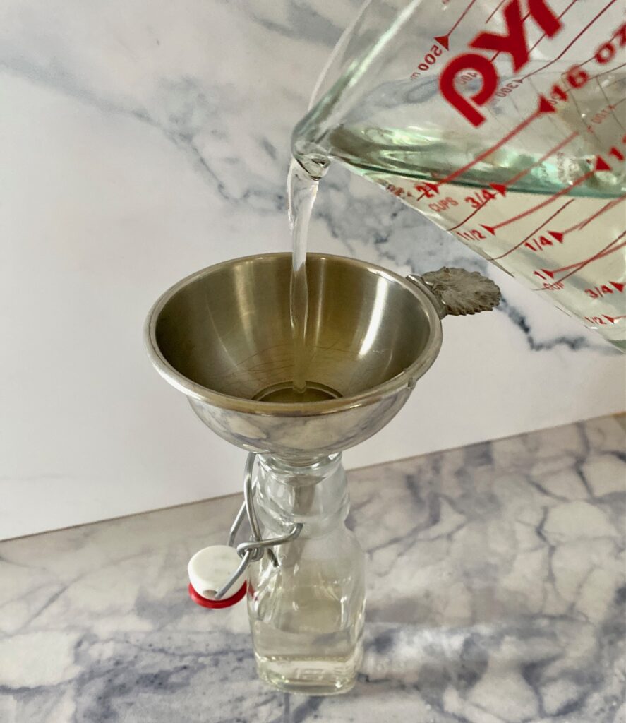 Pouring simple syrup into a jar