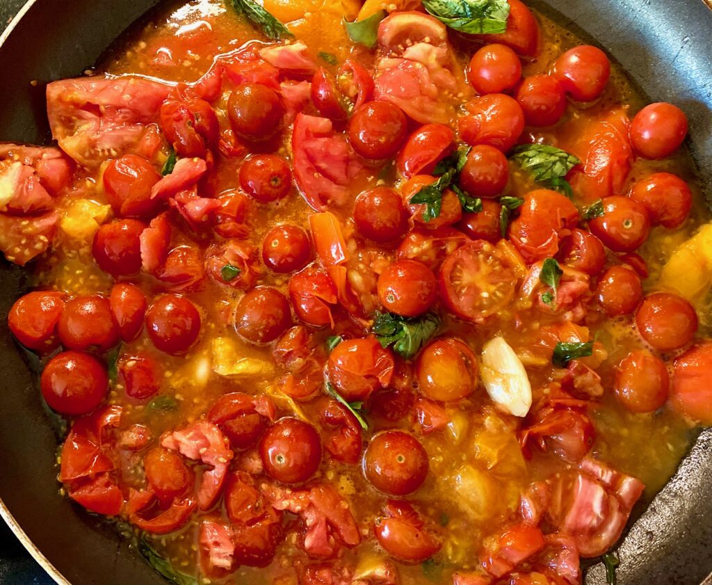 reducing tomatoes in a pan
