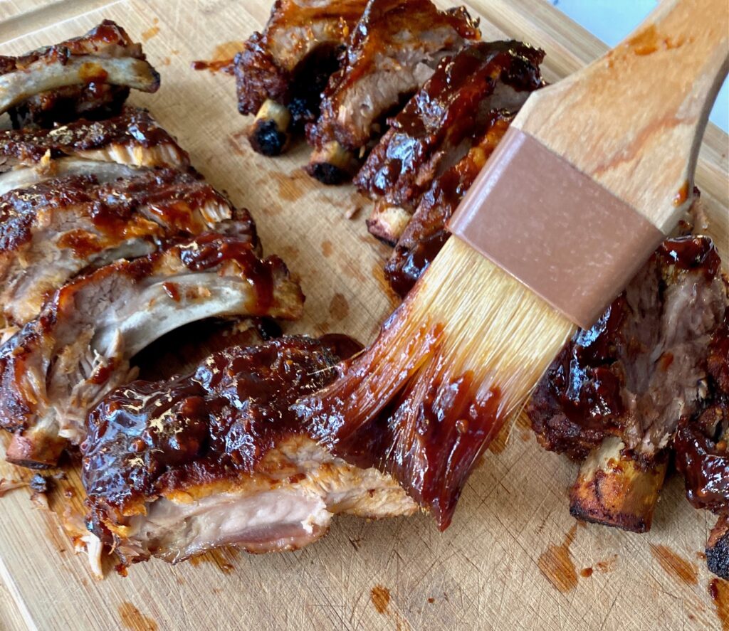 BBQ Sauce and ribs on a cutting board
