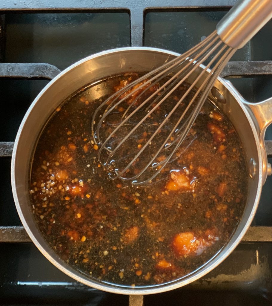 Sauce for Baked Asian Chicken in a pan with whisk