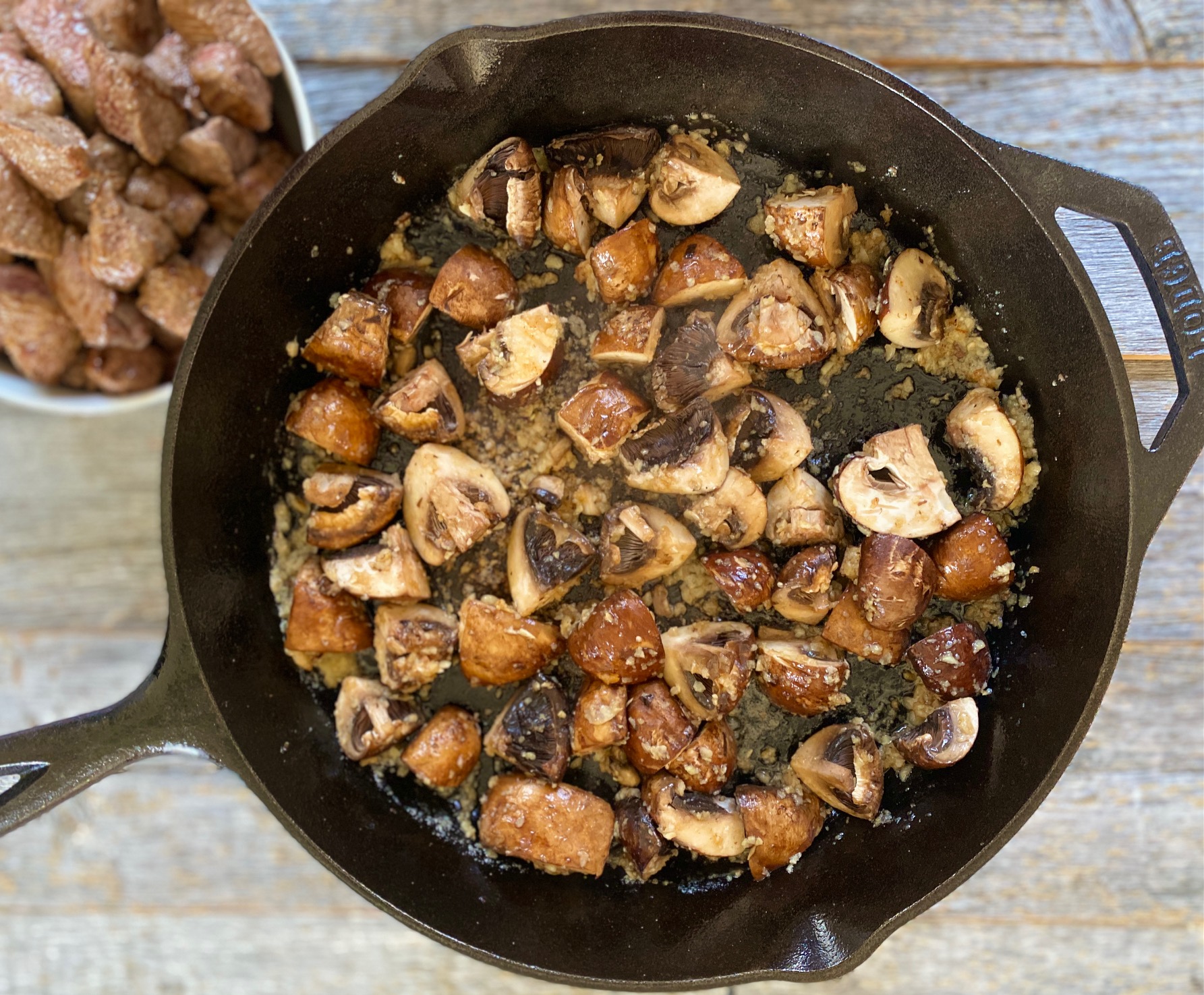Sauteeing mushrooms in a cast iron pan