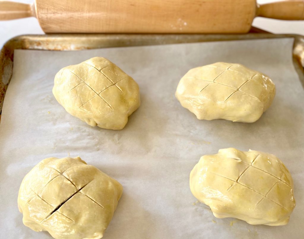 4 beef wellington's wrapped in puff pastry on a tray