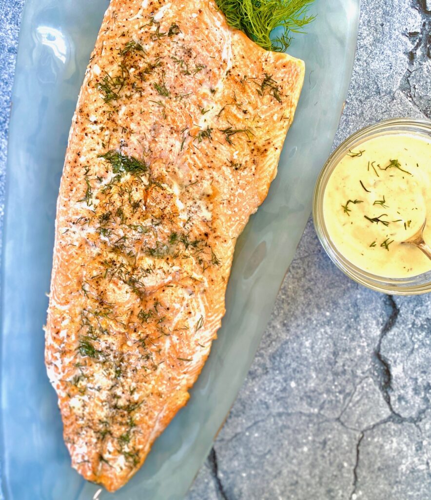 Side of salmon on platter and bowl of sauce