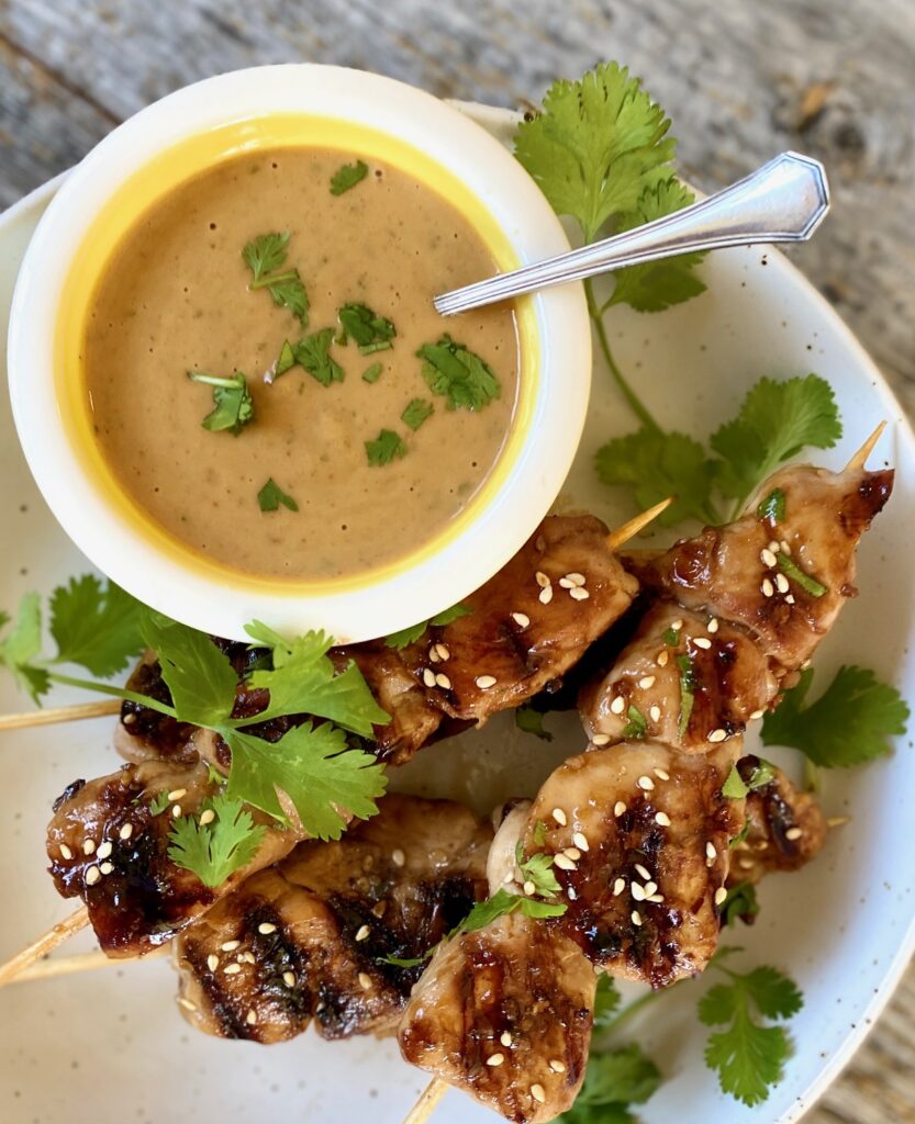bowl of peanut sauce and chicken satay