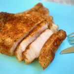 Sliced pork chops on blue cutting board