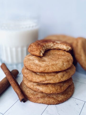 stack of snickerdoodle with bite missing and milk glass