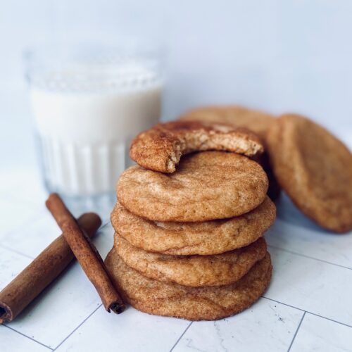 stack of snickerdoodle with bite missing and milk glass
