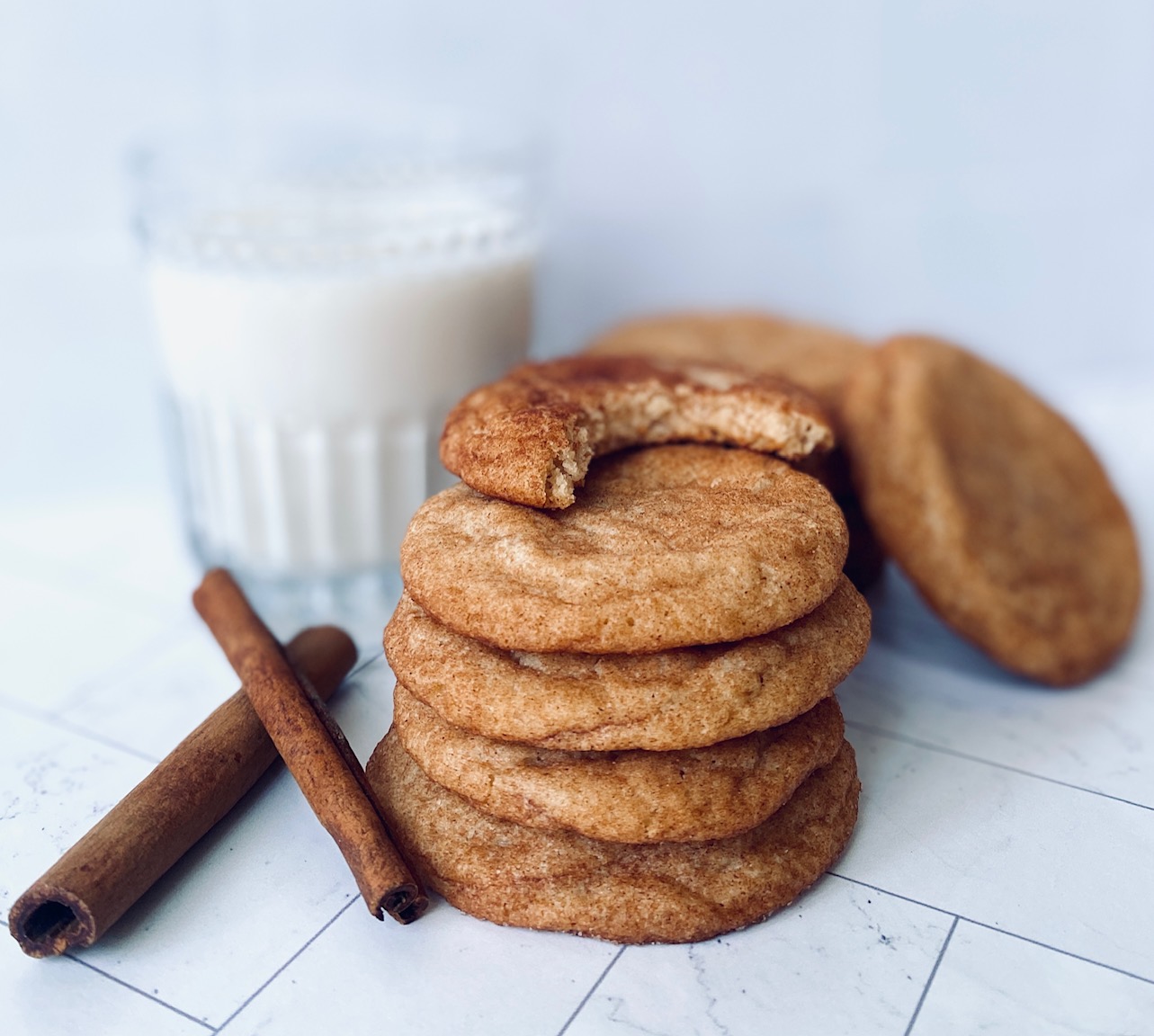 stack of snickerdoodle with bite missing and milk glass
