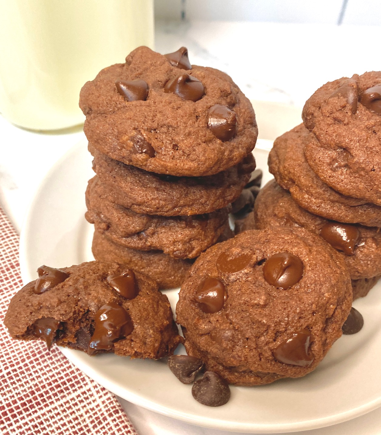 A Stack of Double Choc Cookies with milk on white plate
