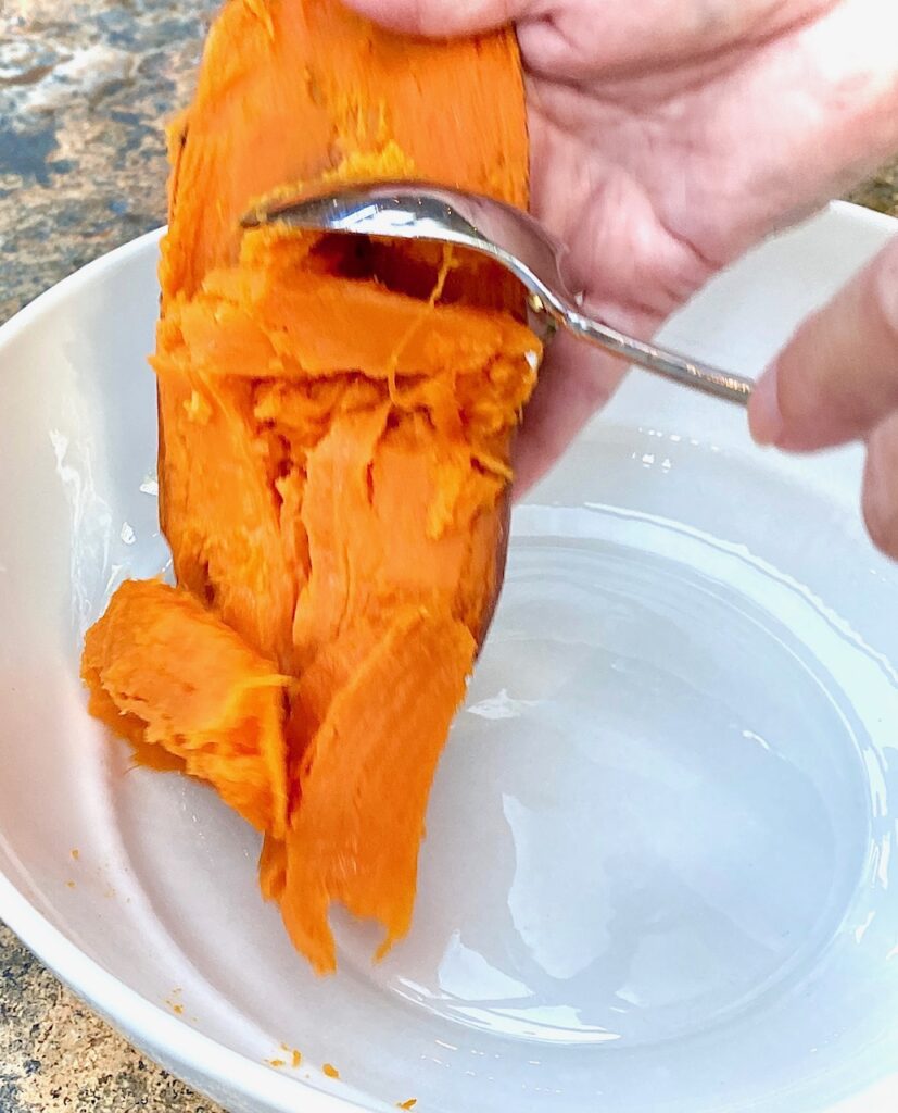 Scooping out roasted sweet potatoes