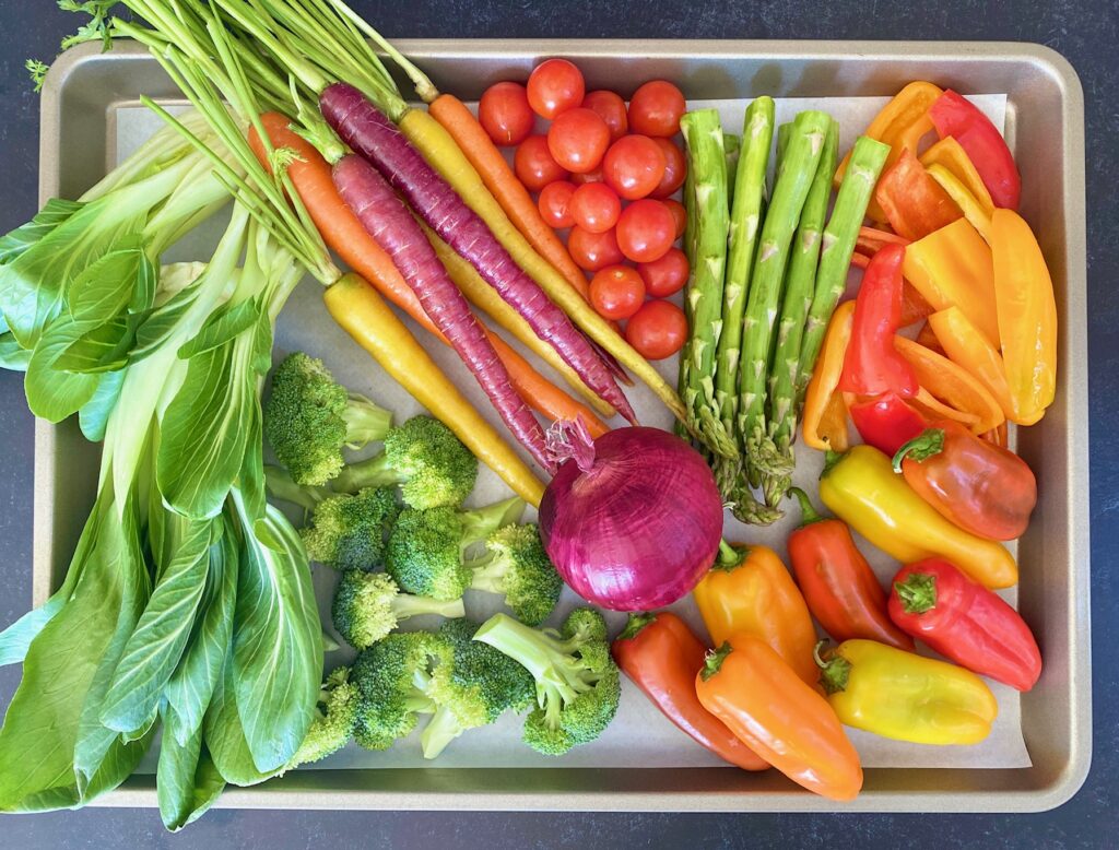 a silver sheet pan of raw vegetables