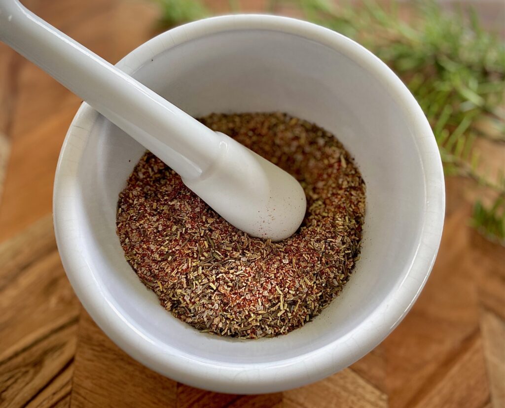 white mortar and pestle with turkey rub seasoning inside.